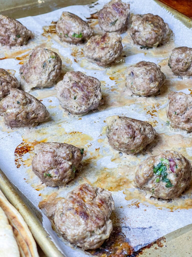 An easy and quick weeknight dinner, Greek Inspired Sheet Pan Meatballs are juicy meatballs bursting with familiar Greek flavors, baked on a sheet pan for fast clean, the perfect meal to make on a busy night. These Greek Meatballs are made with ground beef (or substitute lamb, chicken or turkey), garlic, red onion, and aromatic herbs like oregano, parsley, and mint. They’re tender, juicy, and packed with Mediterranean flair. Perfect for serving with tzatziki sauce, pita bread, or a fresh Greek salad, these meatballs are versatile enough for appetizers or a main meal. Shake up your usual dinner!