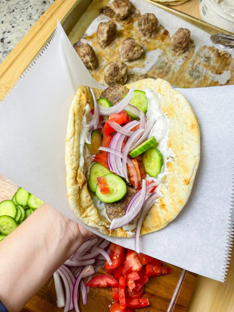 An easy and quick weeknight dinner, Greek Inspired Sheet Pan Meatballs are juicy meatballs bursting with familiar Greek flavors, baked on a sheet pan for fast clean, the perfect meal to make on a busy night. These Greek Meatballs are made with ground beef (or substitute lamb, chicken or turkey), garlic, red onion, and aromatic herbs like oregano, parsley, and mint. They’re tender, juicy, and packed with Mediterranean flair. Perfect for serving with tzatziki sauce, pita bread, or a fresh Greek salad, these meatballs are versatile enough for appetizers or a main meal. Shake up your usual dinner!