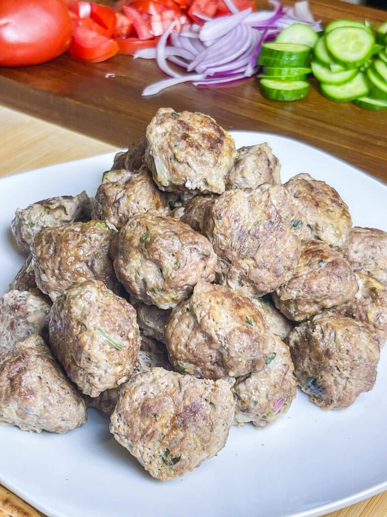 An easy and quick weeknight dinner, Greek Inspired Sheet Pan Meatballs are juicy meatballs bursting with familiar Greek flavors, baked on a sheet pan for fast clean, the perfect meal to make on a busy night. 

These Greek Meatballs are made with ground beef (or substitute lamb, chicken or turkey), garlic, red onion, and aromatic herbs like oregano, parsley, and mint.  They’re tender, juicy, and packed with Mediterranean flair. 

Perfect for serving with tzatziki sauce, pita bread, or a fresh Greek salad, these meatballs are versatile enough for appetizers or a main meal. Shake up your usual dinner!