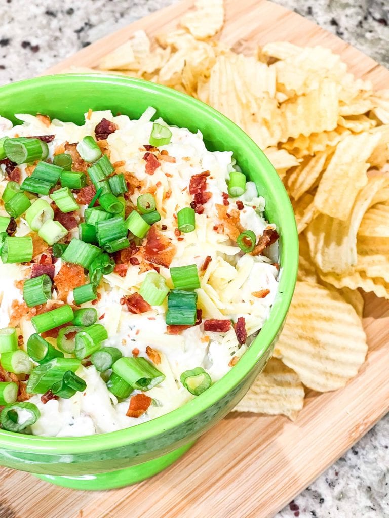 Loaded chip dip is an easy and quick dip recipe made with sour cream, cream cheese, crispy bacon, cheddar cheese, ranch seasoning and green onion that’s perfect for a party, tailgate, or any night of the week and is ready in less than 20 minutes.