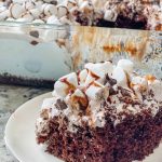 Hot chocolate poke cake is perfect for holiday entertaining and Christmas parties because it's indulgent, delicious, makes many servings and is simple to prepare with boxed chocolate cake mix, marshmallow fluff, hot fudge sauce and hot chocolate whipped topping with mini marshmallow on top.