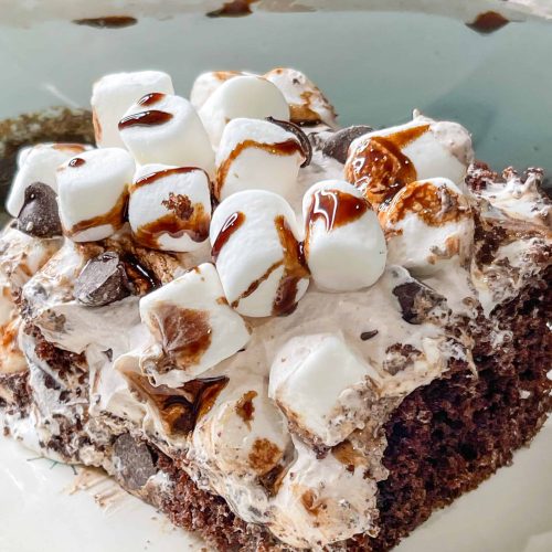 Hot chocolate poke cake is perfect for holiday entertaining and Christmas parties because it's indulgent, delicious, makes many servings and is simple to prepare with boxed chocolate cake mix, marshmallow fluff, hot fudge sauce and hot chocolate whipped topping with mini marshmallow on top.