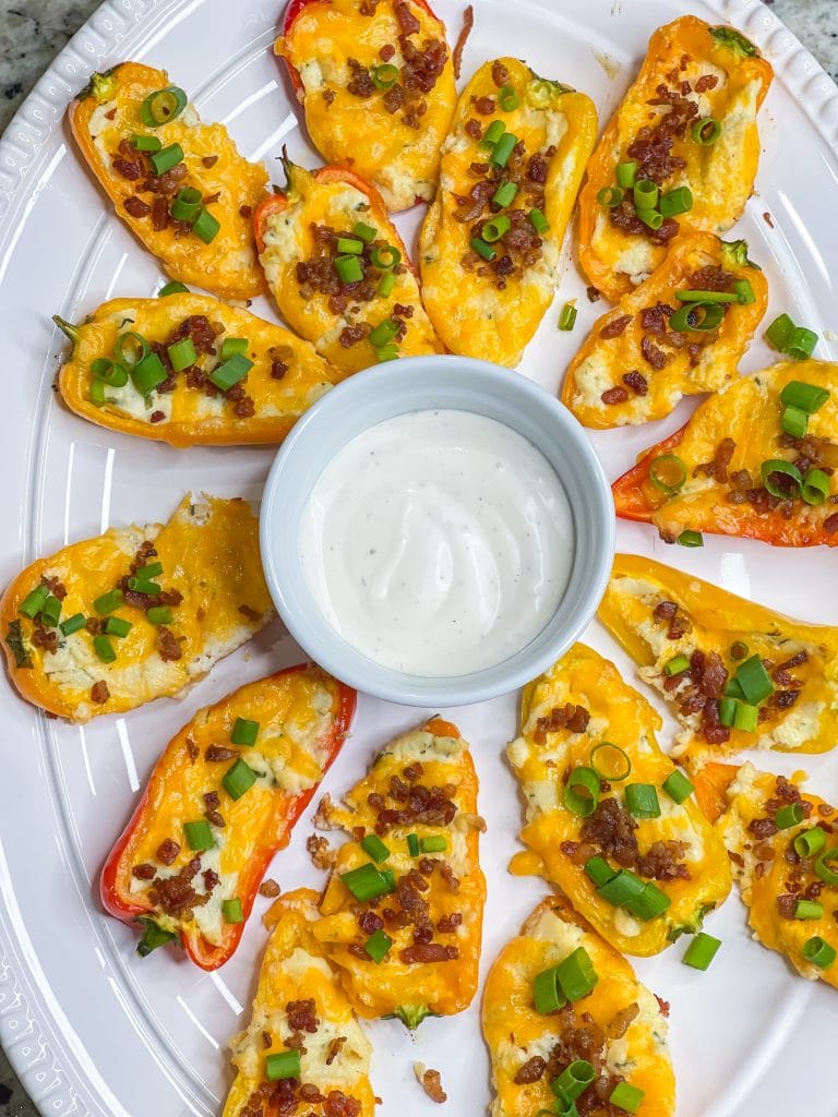 Boursin Cheese Pepper Poppers are my go-to snack to make for game day! Mini sweet peppers are stuffed with savory Boursin cheese and sharp cheddar cheese, baked until gooey, and topped with crisp bacon and bright green onions for the perfect cheesy bite.