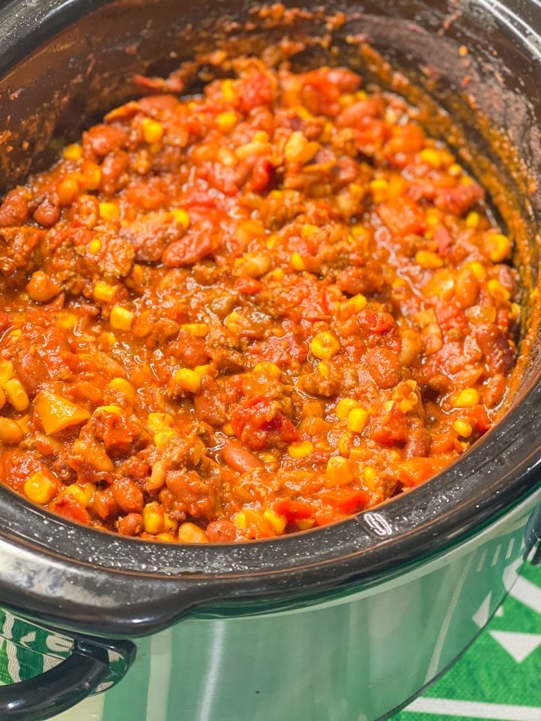 Slow Cooker Chili is hearty and warming, a little spicy, and the perfect dish to serve for game day. Beef and bacon slow cook all day with tomatoes, onions, peppers, and a homemade spice blend for a deeply flavorful soup. Add your favorite toppings for a crowd pleasing and easy bowl of meaty chili.