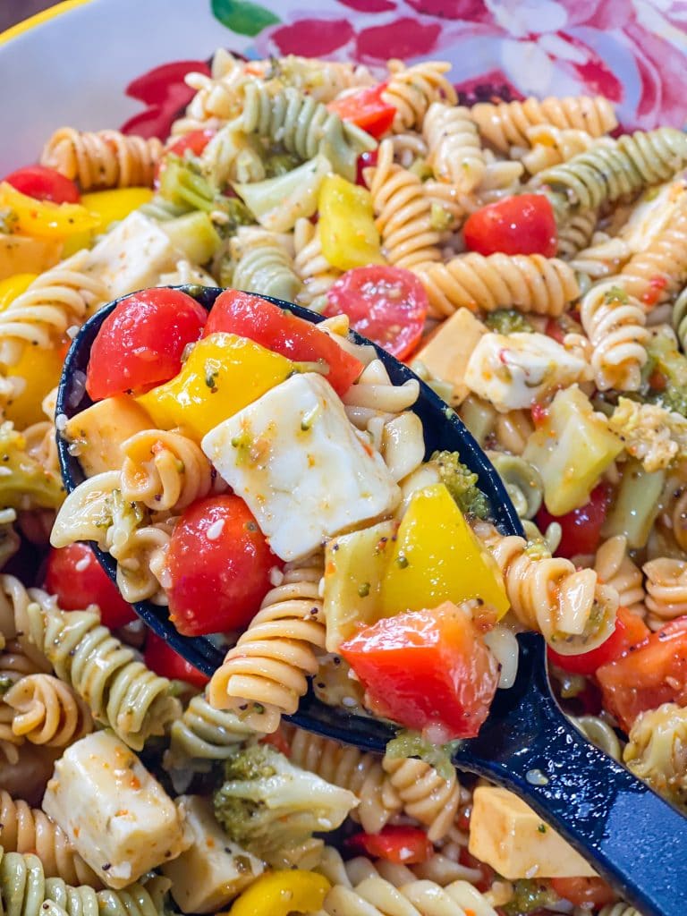 This pasta salad is a  combination of rotini pasta, chunky cheeses, veggies zesty Italian dressing and seasoning is just amazing! Great for any get-together or summer picnic.