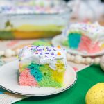 This colorful Easter Poke Cake is sure to delight on your Easter table! This cake is so easy to prepare but looks like an absolute show stopper. All you need is a box of cake mix, food coloring, pudding mix and cool whip for the brightest dessert to WOW your guests.