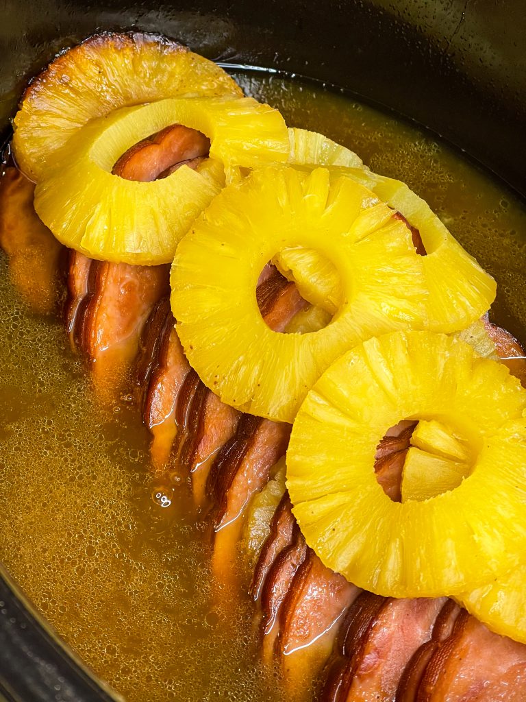 This slow cooked ham is just 6 simple ingredients; a boneless or bone-in spiral ham, brown sugar, canned pineapple, maple syrup, butter and a dash of cloves. Plus, it's a dump-and-go recipe, minimal effort and little clean up required. That is my type of meal!