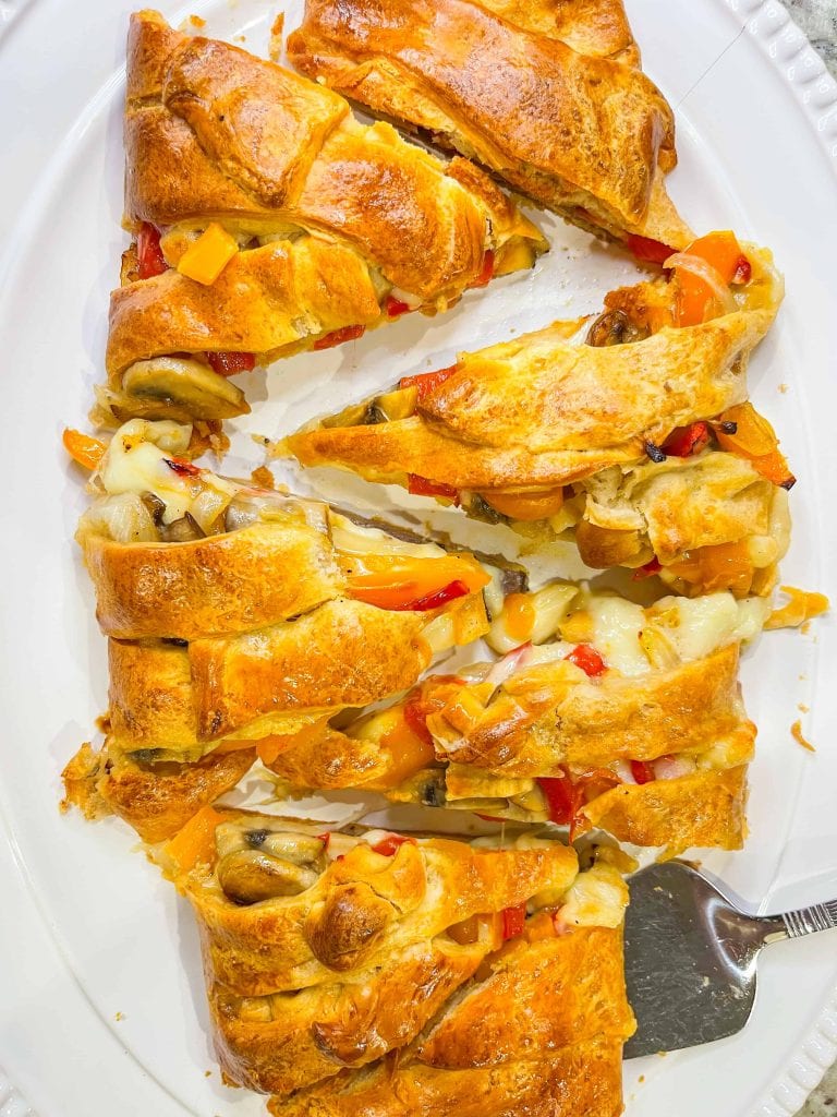 This Cheesesteak Crescent Roll Braid is perfect for any party, on game day, or for an easy weeknight dinner. It starts with a sheet of flaky crescent dough and is filled with roast beef, provolone cheese, horseradish sauce and sauteed veggies. A crowd pleaser, for sure!