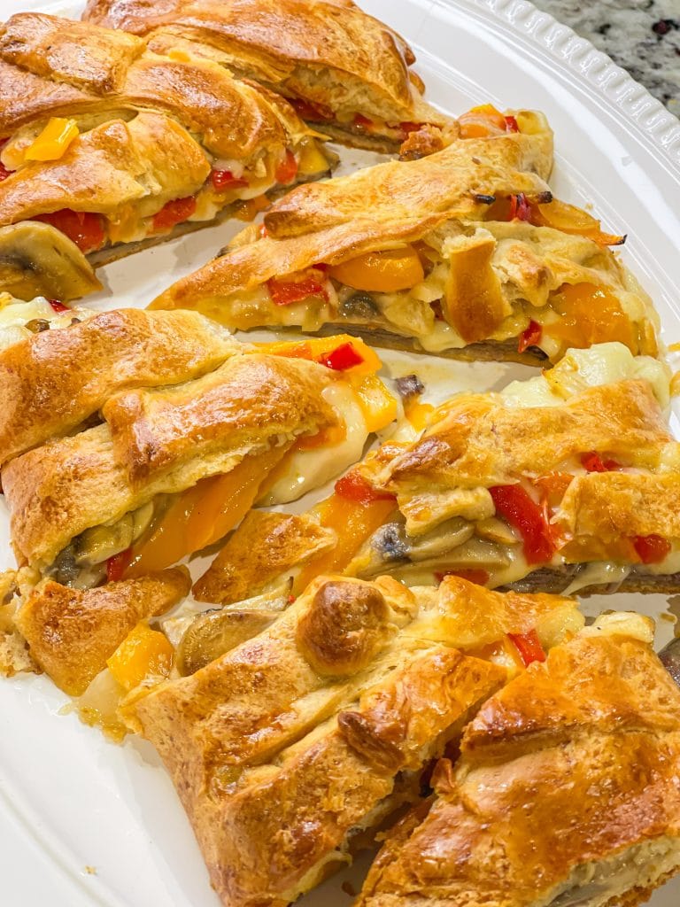 This Cheesesteak Crescent Roll Braid is perfect for any party, on game day, or for an easy weeknight dinner. It starts with a sheet of flaky crescent dough and is filled with roast beef, provolone cheese, horseradish sauce and sauteed veggies. A crowd pleaser, for sure!