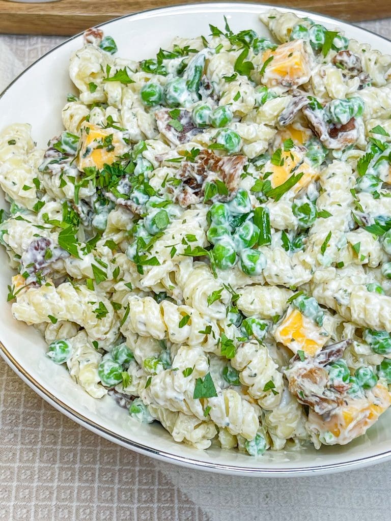 Creamy Bacon Ranch Pasta Salad combines crisp bacon, cheddar cheese, tender pasta with peas for a juicy bite with a creamy ranch dressing. A great summer pasta salad for any occasion.