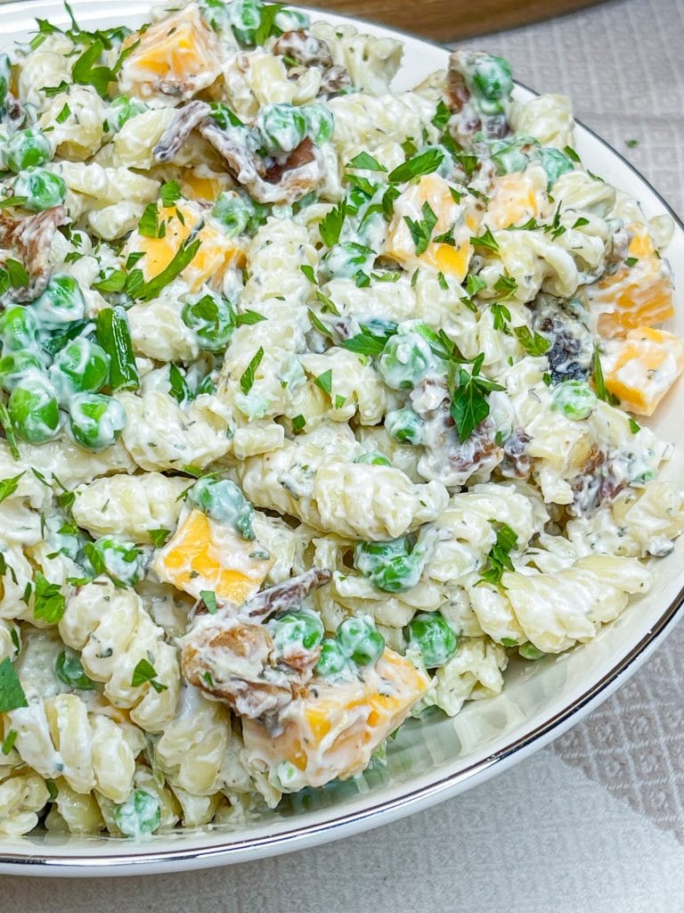 Creamy Bacon Ranch Pasta Salad combines crisp bacon, cheddar cheese, tender pasta with peas for a juicy bite with a creamy ranch dressing. A great summer pasta salad for any occasion.