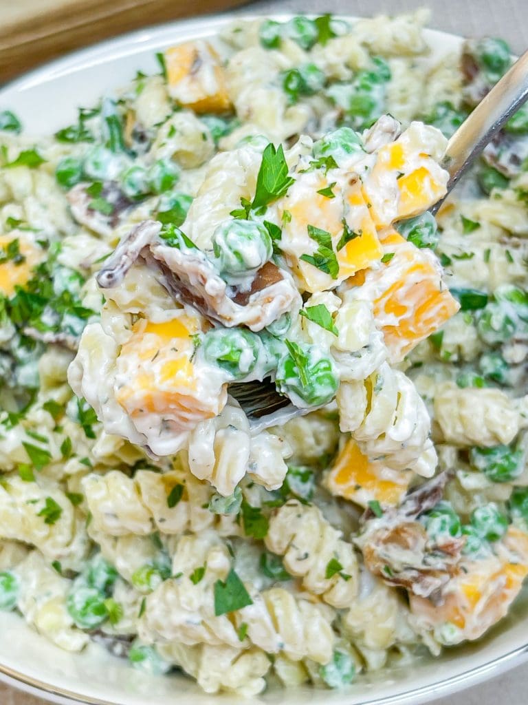 Creamy Bacon Ranch Pasta Salad combines crisp bacon, cheddar cheese, tender pasta with peas for a juicy bite with a creamy ranch dressing. A great summer pasta salad for any occasion.