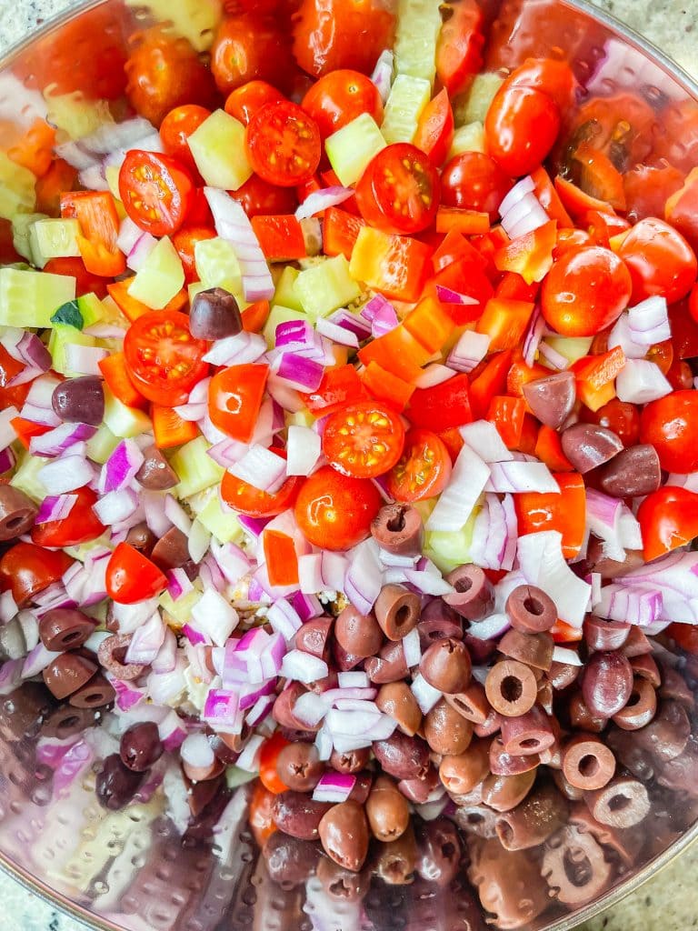 If you love the flavors of the Mediterranean, you'll love this Greek Pasta Salad with tender pasta, kalamata olives, red peppers, cucumbers, juicy tomatoes, tangy red onion, and creamy feta cheese all tossed in an herby olive oil dressing.