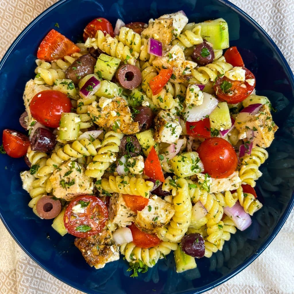 If you love the flavors of the Mediterranean, you'll love this Greek Pasta Salad with tender pasta, kalamata olives, red peppers, cucumbers, juicy tomatoes, tangy red onion, and creamy feta cheese all tossed in an herby olive oil dressing.