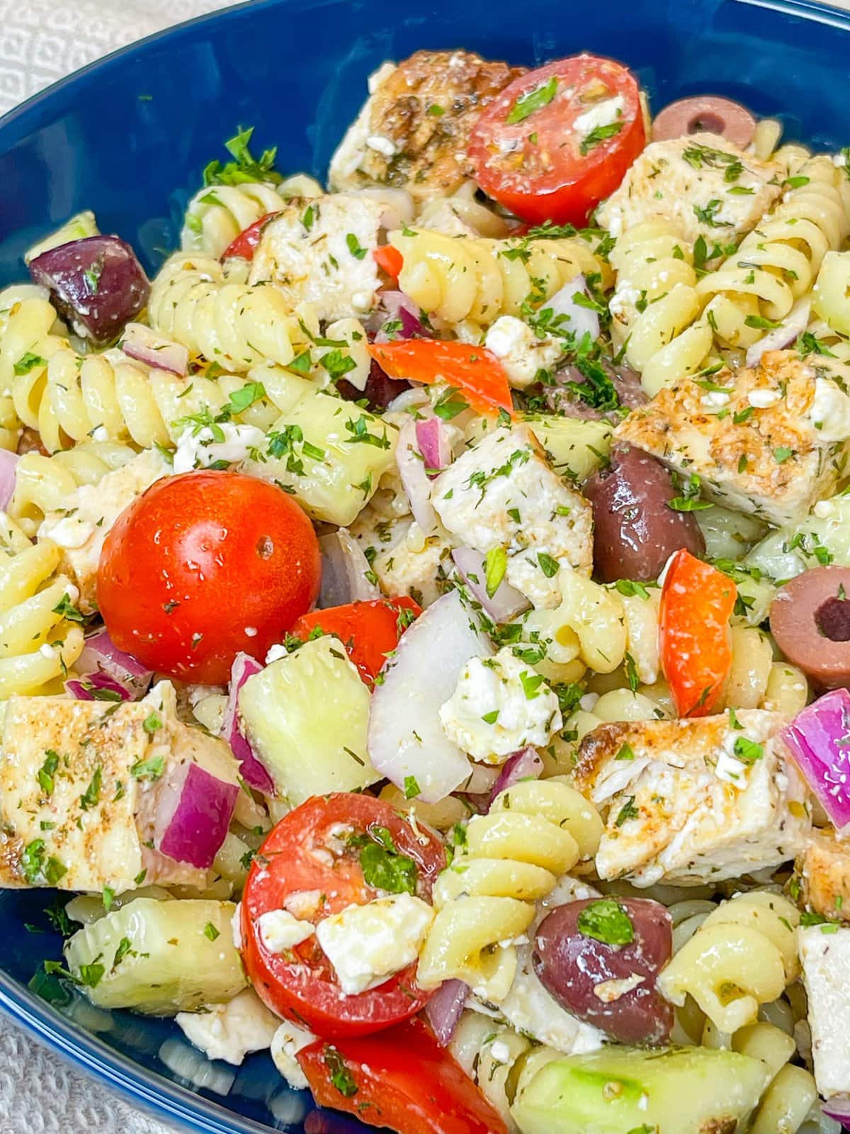 If you love the flavors of the Mediterranean, you'll love this Greek Pasta Salad with tender pasta, kalamata olives, red peppers, cucumbers, juicy tomatoes, tangy red onion, and creamy feta cheese all tossed in an herby olive oil dressing.