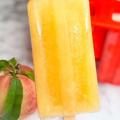 These adult only winesicles are made with 3 simple ingredients blended together-peaches (fresh, frozen, or canned), orange juice, and white wine. They are quick and simple to make and are my favorite way to cool off in the summer. Picture it- the hot sun, a pool, and a cold peach winesicle. Yes, please!