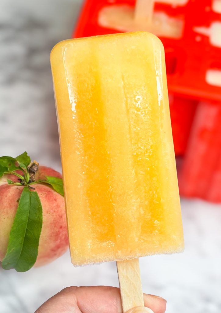 These adult only winesicles are made with 3 simple ingredients blended together-peaches (fresh, frozen, or canned), orange juice, and white wine. They are quick and simple to make and are my favorite way to cool off in the summer. Picture it- the hot sun, a pool, and a cold peach winesicle. Yes, please!