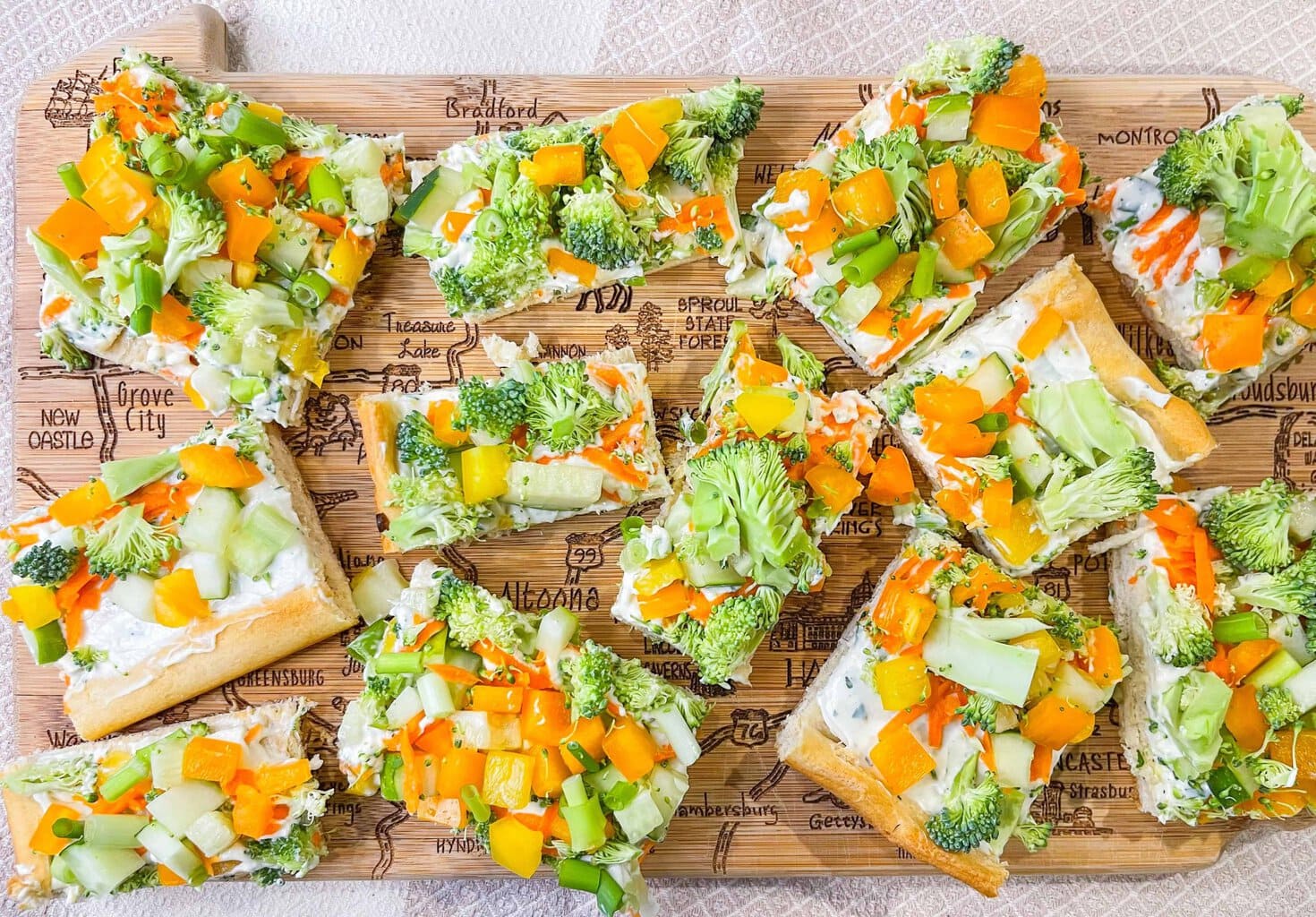 This Crescent Dough Veggie Pizza is the perfect appetizer for any occasion! It starts with a roll of crescent dough with seasoned cream cheese spread across the baked dough and topped with fresh vegetables. It's easy, flavorful, and a crowd pleaser!