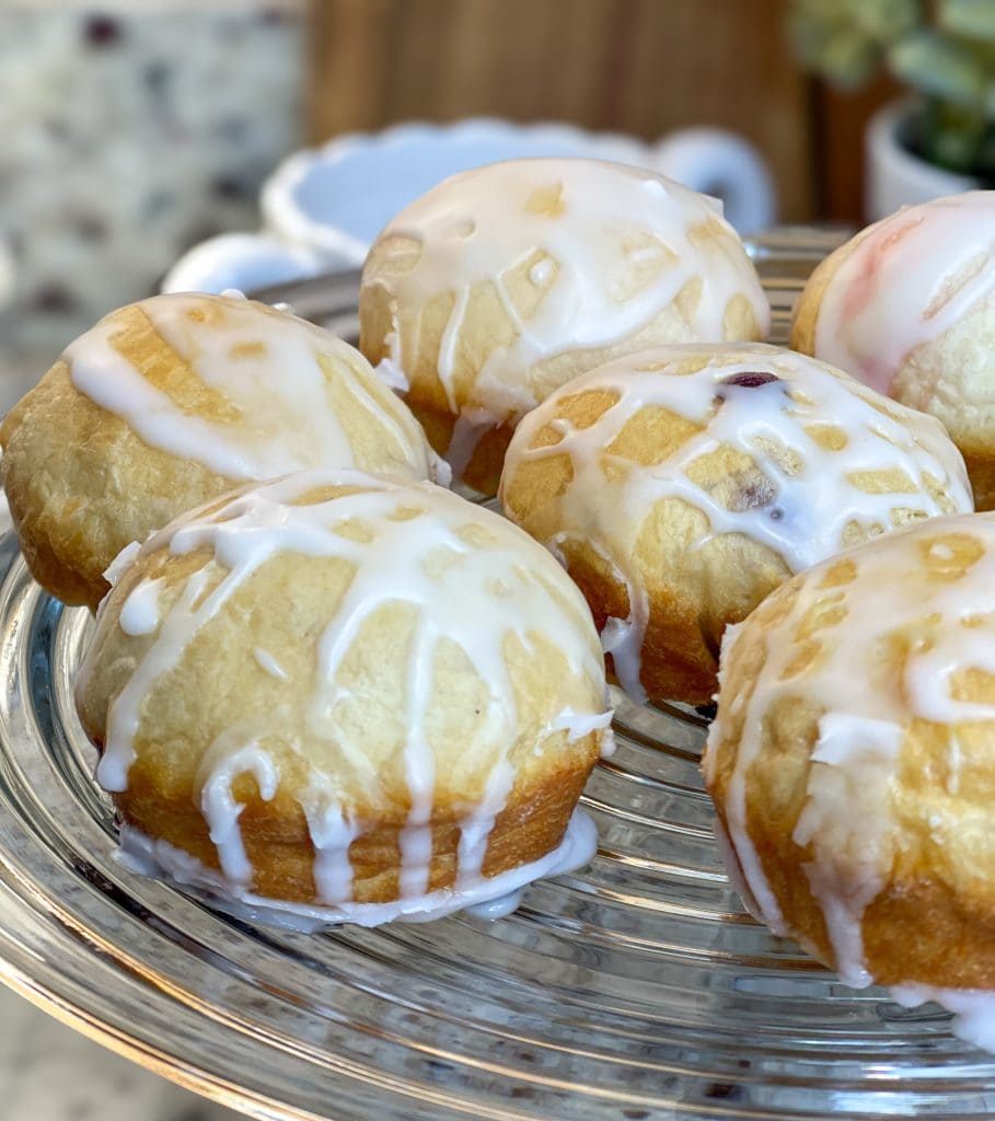 Fruity Pie Biscuit Bombs are delicious little nuggets of blueberry and cherry pie filling (or any fruit pie filling you like!) stuffed into a flaky biscuit round, baked, and covered in a powdered sugar glaze.