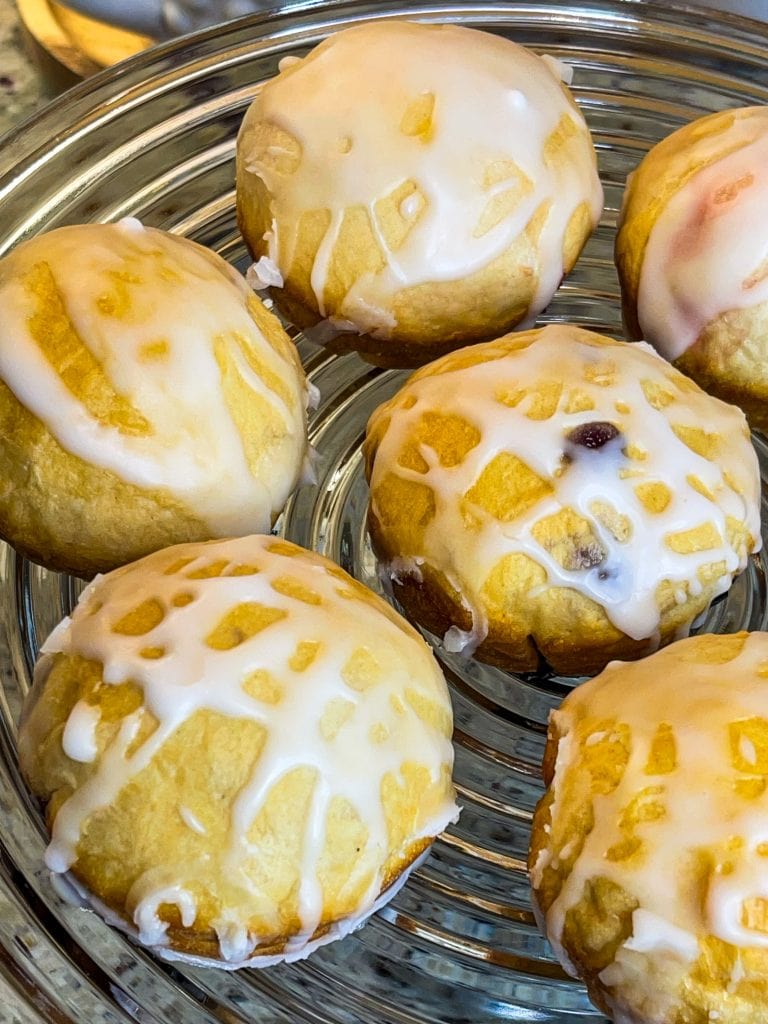 Fruity Pie Biscuit Bombs are delicious little nuggets of blueberry and cherry pie filling (or any fruit pie filling you like!) stuffed into a flaky biscuit round, baked, and covered in a powdered sugar glaze.