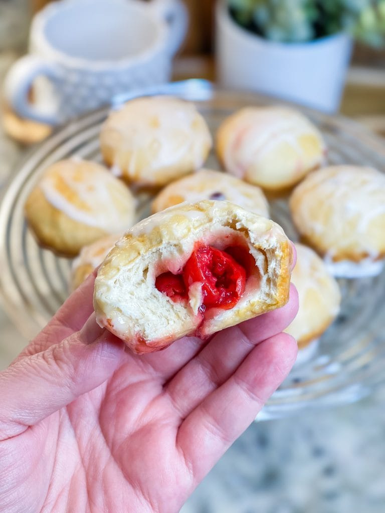 Fruity Pie Biscuit Bombs are delicious little nuggets of blueberry and cherry pie filling (or any fruit pie filling you like!) stuffed into a flaky biscuit round, baked, and covered in a powdered sugar glaze.