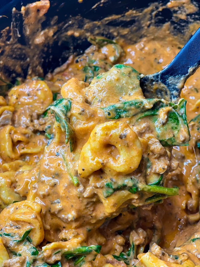 The whole family is going to love this easy weeknight Crock Pot Cheesy Tortellini dinner. It's creamy, rich and filling with tortellini, cream cheese, a hearty meat sauce and spinach.