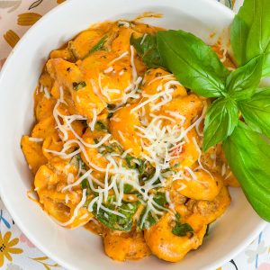 The whole family is going to love this easy weeknight Crock Pot Cheesy Tortellini dinner. It's creamy, rich and filling with tortellini, cream cheese, a hearty meat sauce and spinach.