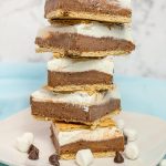 Glide through the lazy days of summer with these refreshing Frozen S'mores bars. These cool treats are made with graham crackers, chocolate pudding, marshmallow fluff, cream cheese, and whipped cream. Perfect for any summer occasion!