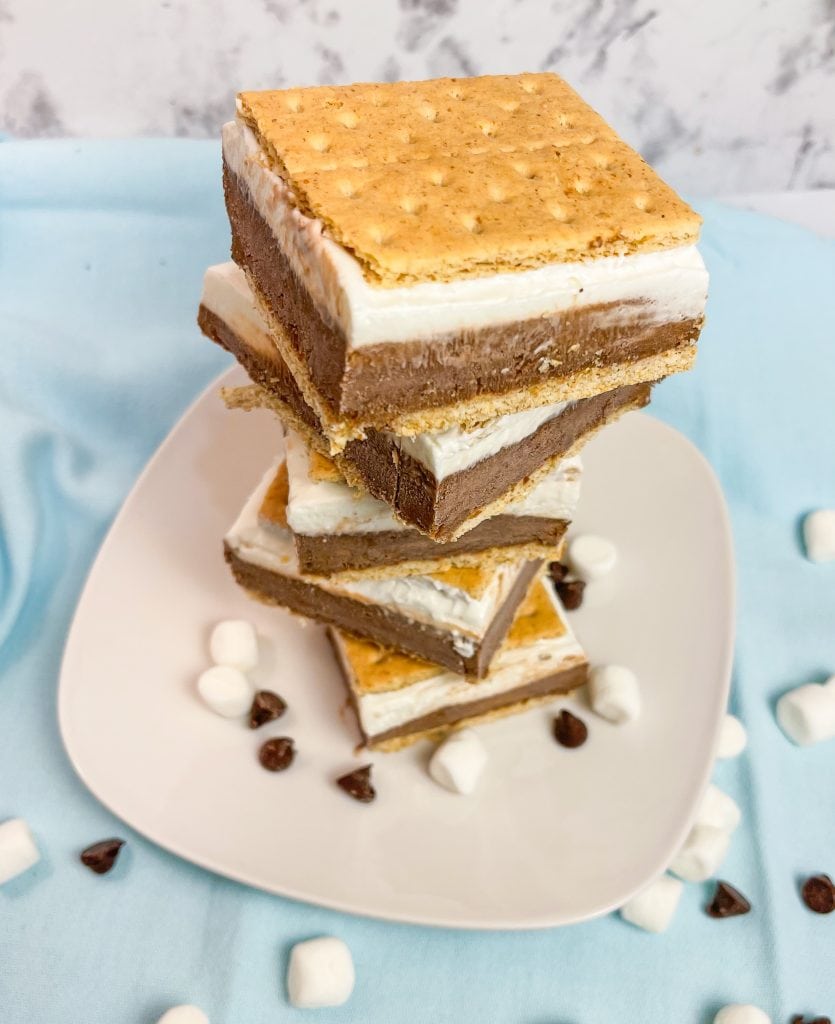 Glide through the lazy days of summer with these refreshing Frozen S'mores bars. These cool treats are made with graham crackers, chocolate pudding, marshmallow fluff, cream cheese, and whipped cream. Perfect for any summer occasion!