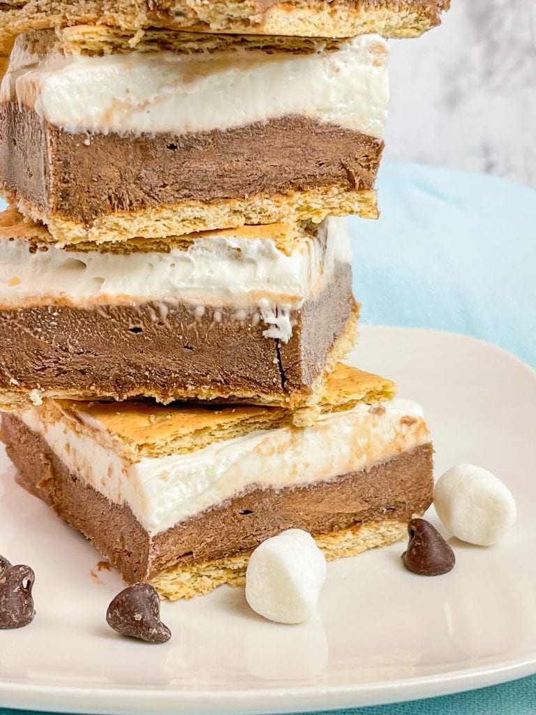 Glide through the lazy days of summer with these refreshing Frozen S'mores bars. These cool treats are made with graham crackers, chocolate pudding, marshmallow fluff, cream cheese, and whipped cream. Perfect for any summer occasion! 