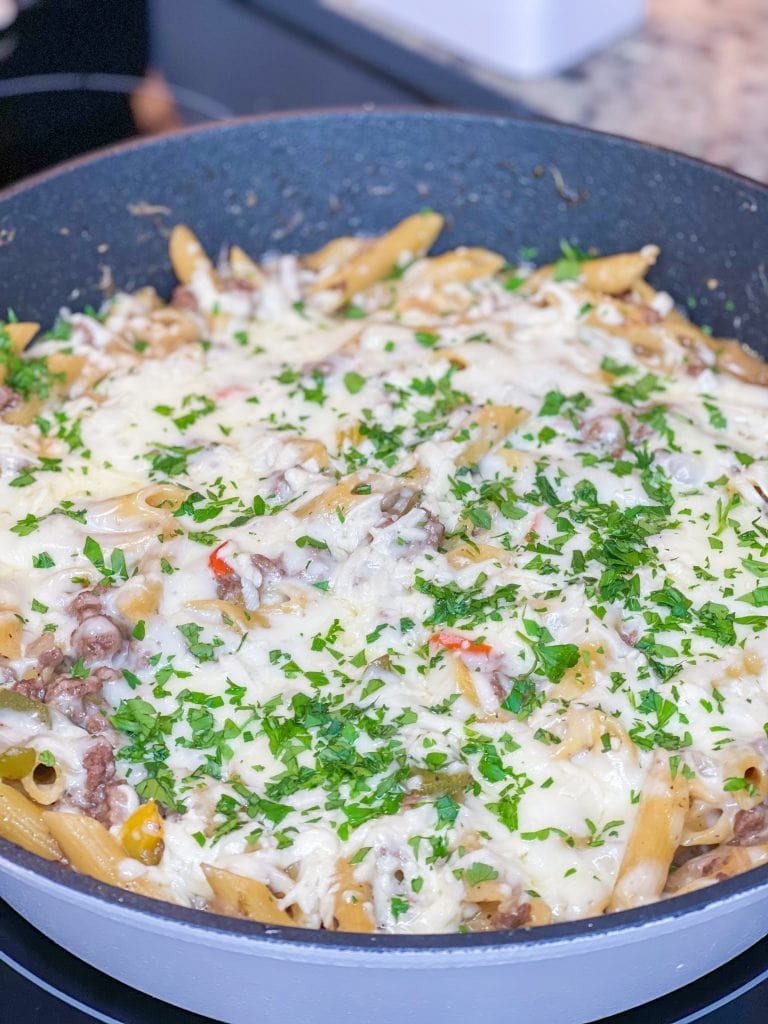 This One Pan Cheesesteak Pasta is filled with ground beef, peppers, onions, penne pasta, and of course, cheese! It's made all in one pan for an easy, family friendly weeknight dinner.