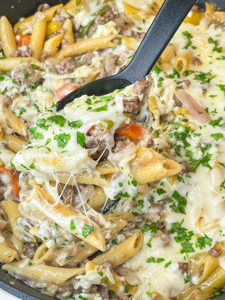 This One Pan Cheesesteak Pasta is filled with ground beef, peppers, onions, penne pasta, and of course, cheese! It's made all in one pan for an easy, family friendly weeknight dinner.