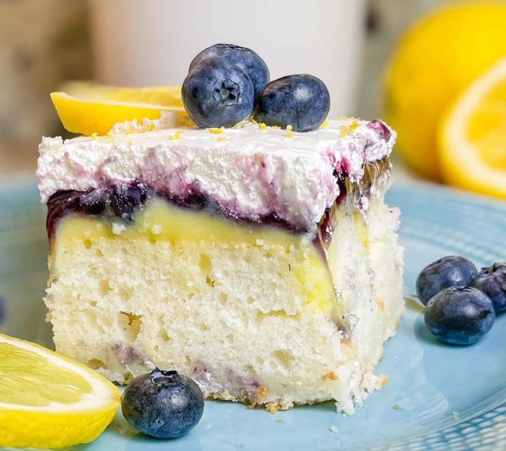 Blueberry Lemon Poke Cake is a refreshing treat great for any time of the year. It's a lemon spiked cake mix topped with creamy lemon pudding, blueberry pie filling and Cool Whip. Easy and delicious!