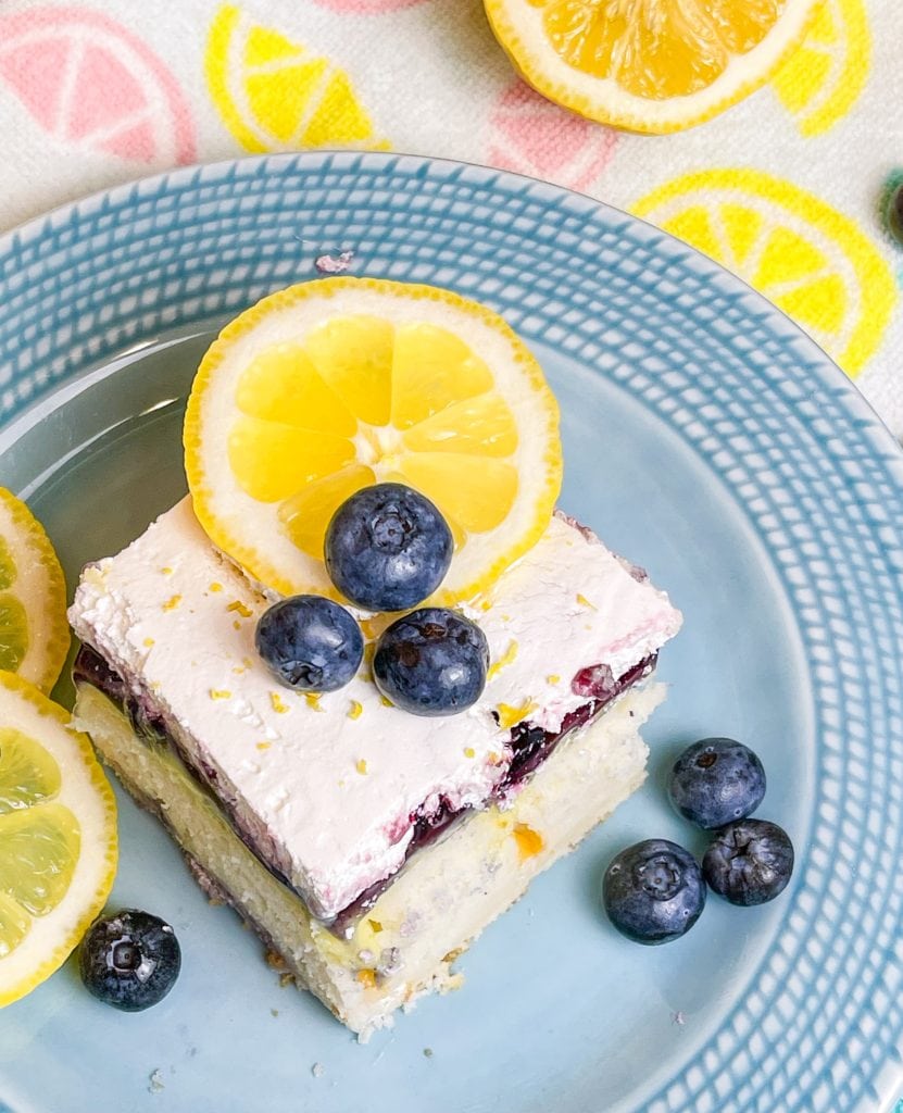 Blueberry Lemon Poke Cake is a refreshing treat great for any time of the year. It's a lemon spiked cake mix topped with creamy lemon pudding, blueberry pie filling and Cool Whip. Easy and delicious!