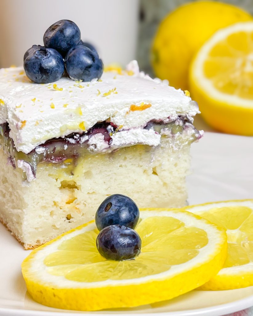 Blueberry Lemon Poke Cake is a refreshing treat great for any time of the year. It's a lemon spiked cake mix topped with creamy lemon pudding, blueberry pie filling and Cool Whip. Easy and delicious!