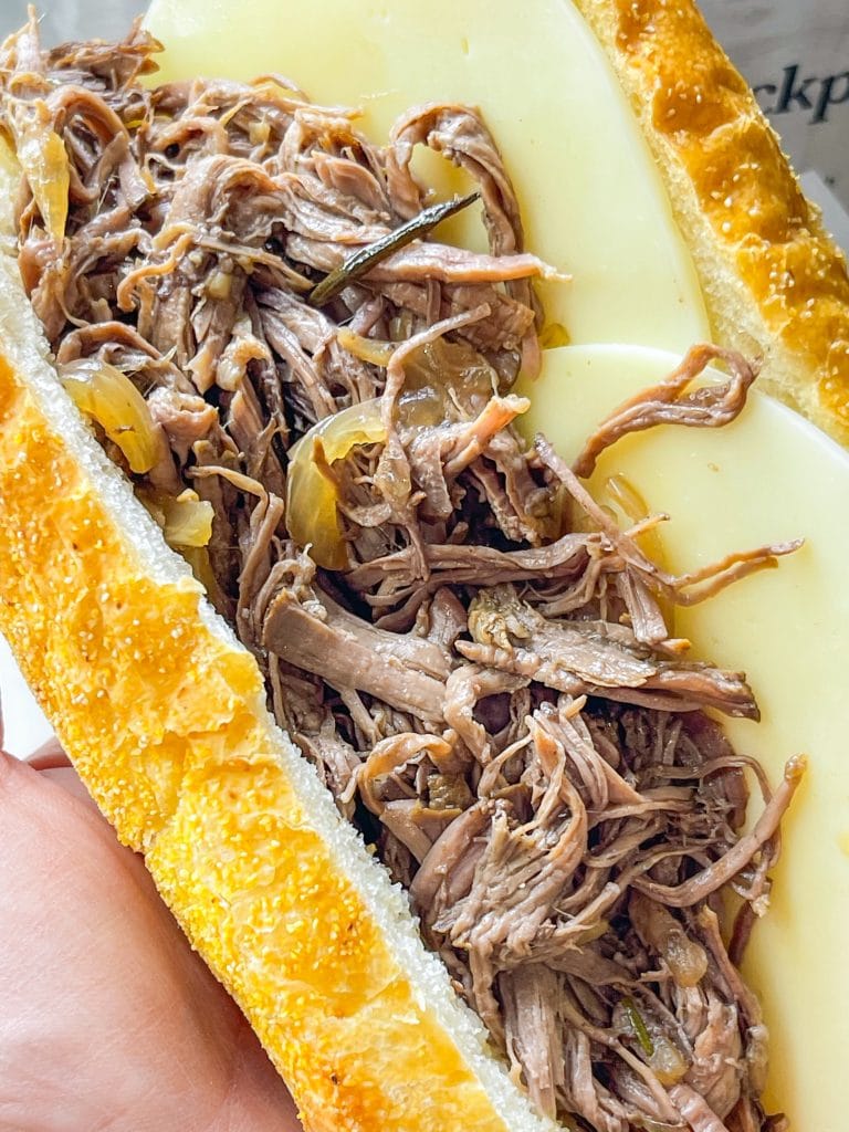 Slow Cooker French Dip Sandwiches are juicy, beefy sandwiches that start with a chuck roast and slow cooked all day that results in a tender beef sandwich with melty cheese on a hearty hoagie bun.