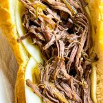 Slow Cooker French Dip Sandwiches are juicy, beefy sandwiches that start with a chuck roast and slow cooked all day that results in a tender beef sandwich with melty cheese on a hearty hoagie bun.