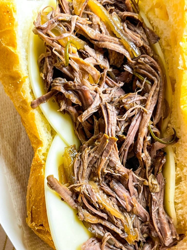 Slow Cooker French Dip Sandwiches are juicy, beefy sandwiches that start with a chuck roast and slow cooked all day that results in a tender beef sandwich with melty cheese on a hearty hoagie bun.