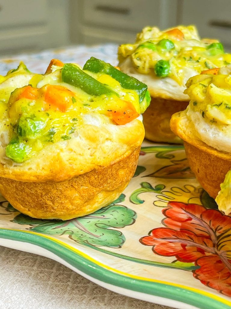 Mini Chicken Pot Pies are delicious little muffins, made with only 4 main ingredients: refrigerated biscuit dough, rotisserie chicken, frozen mixed vegetables, and cream of chicken soup. These delicious pies make a kid-friendly, quick, weeknight dinner!