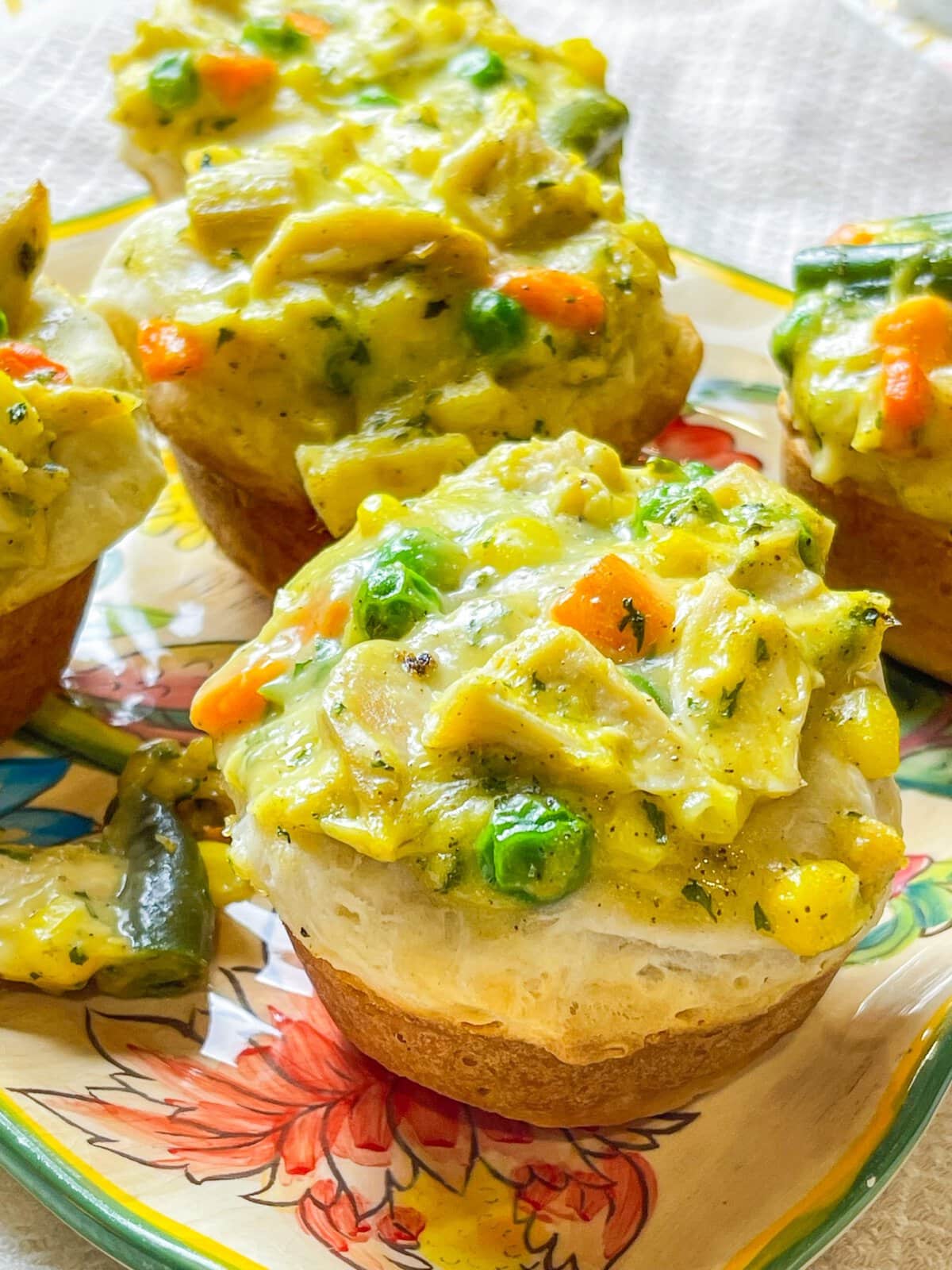 Mini Chicken Pot Pies are delicious little muffins, made with only 4 main ingredients: refrigerated biscuit dough, rotisserie chicken, frozen mixed vegetables, and cream of chicken soup. These delicious pies make a kid-friendly, quick, weeknight dinner!