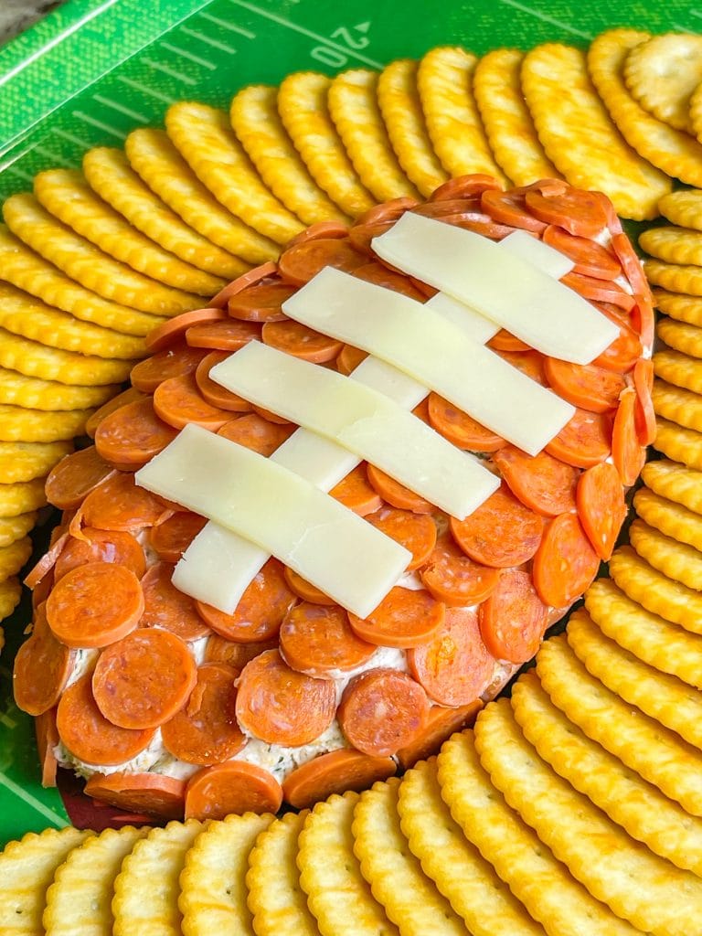 This is the easiest dip to throw together, even last minute! Football Cheese Dip is made with simple panty ingredients: cream cheese, cheddar cheese, and seasonings, but is elevated with the addition of mini pepperoni to resemble a football. Your family and guests will rave! This recipe is easily doubled or tripled for a large crowd and can be prepared a day or two before serving so on game day you can have fun without the hassle.