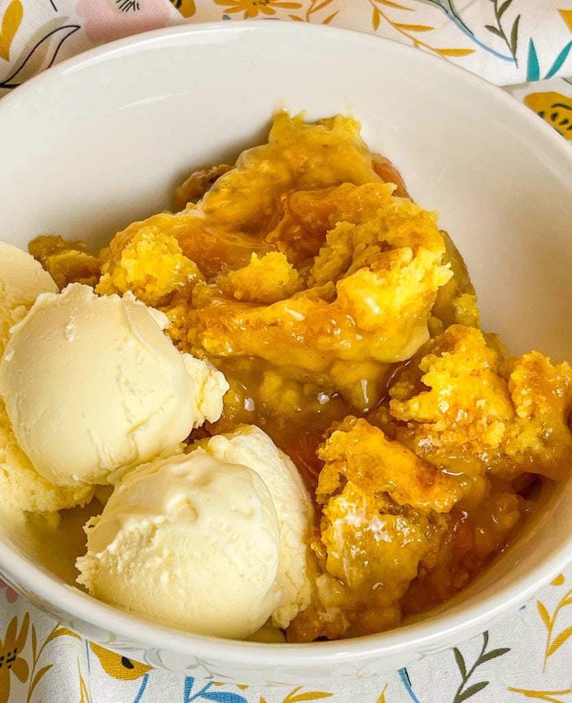 You'll love this Crock Pot Peach Cobbler because it's only 3 simple ingredients, it's the perfect dessert for any occasion, and it's a cinch to put together. This crock pot peach cobbler is my go-to dessert for a potluck for family gathering when I'm short on time. It's only 3 ingredients! The ingredients are peach pie filling, yellow cake mix, and butter. That's it! It takes literally 5 minutes to prep, it's inexpensive to make and it feeds a lot of people.