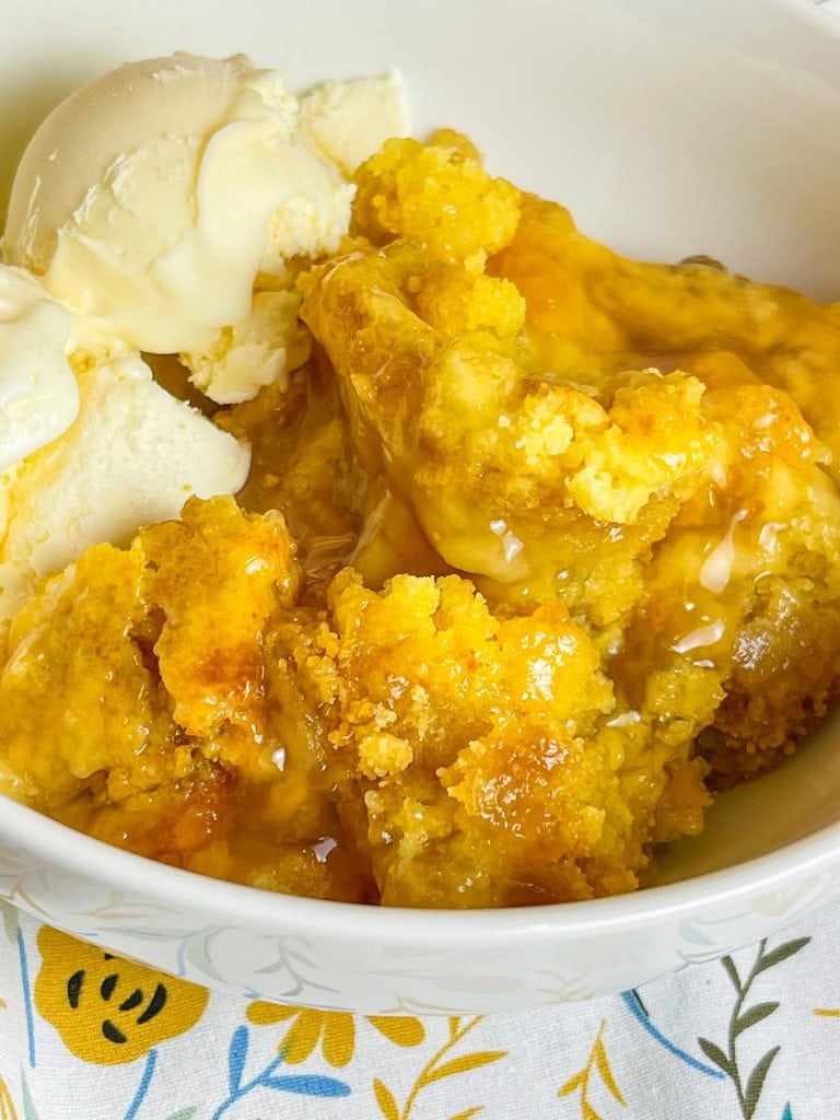 You'll love this Crock Pot Peach Cobbler because it's only 3 simple ingredients, it's the perfect dessert for any occasion, and it's a cinch to put together. This crock pot peach cobbler is my go-to dessert for a potluck for family gathering when I'm short on time. It's only 3 ingredients! The ingredients are peach pie filling, yellow cake mix, and butter. That's it! It takes literally 5 minutes to prep, it's inexpensive to make and it feeds a lot of people.