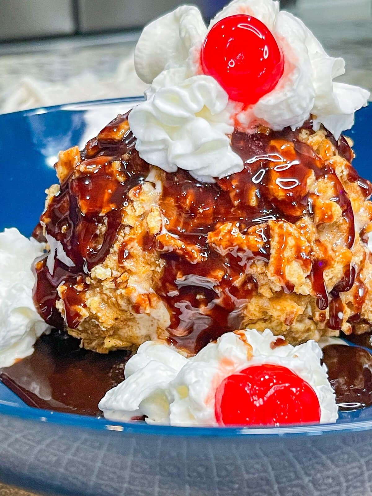 Air Fryer Fried Ice Cream is such a treat and easier to make than you might think. It's vanilla ice cream coated in cinnamon sugar cereal and air fried so the inside is cool and creamy and the outside is crisp and crunchy. Top it with chocolate sauce and whipped cream and you have a dessert that is out of this world!