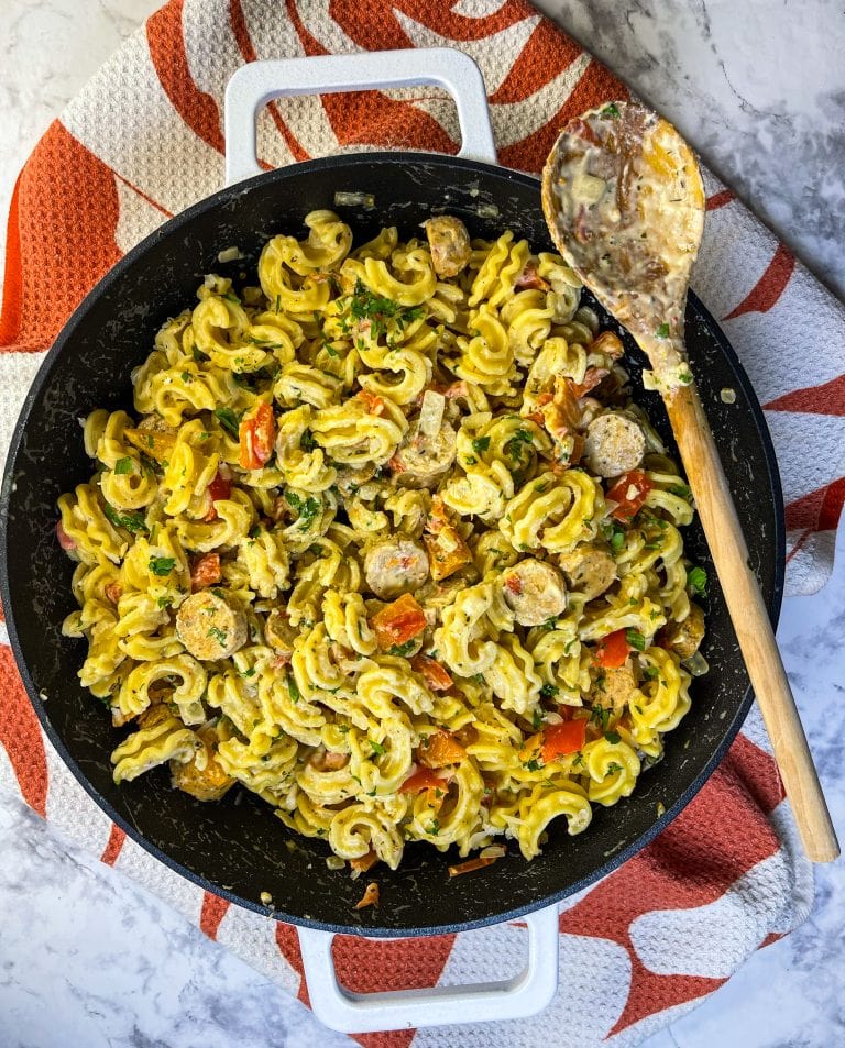 This is one of my easy weeknight go-to dinners. Sausage and Peppers Pasta in ready in about 30 minutes, it's simple to throw together and it's filling. Oh, I forgot to mention, it's delicious! Sausage and Peppers Pasta is made with chicken sausage, bell peppers, and pasta in a cheesy cream sauce. (you had me at cheesy cream sauce) It comes together quick for when you need to get a hearty meal on the table fast.