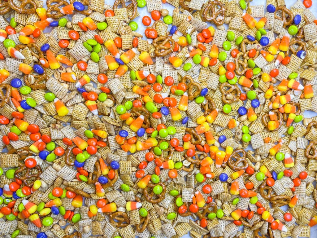 This sweet and salty Monster Mix is the perfect snack mix for the Halloween season. If you are a fan of a sweet and salty combo, then this snack mix is for you! It combines salty peanuts, pretzels and cereal with sweet M&Ms and candy corn in a brown sugar maple glaze. It's perfect for any Halloween or fall gathering.