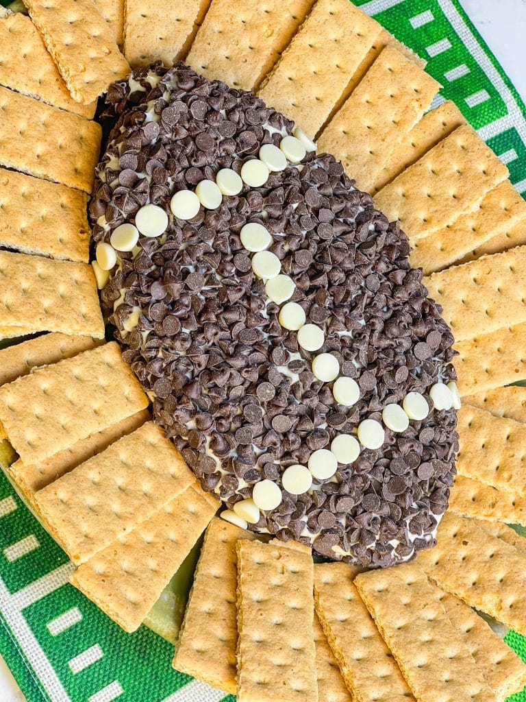 Football Cheesecake Dip is a chocolate chip cheesecake type dip served with graham crackers for dipping. It's a fun and sweet addition to any tailgate table.