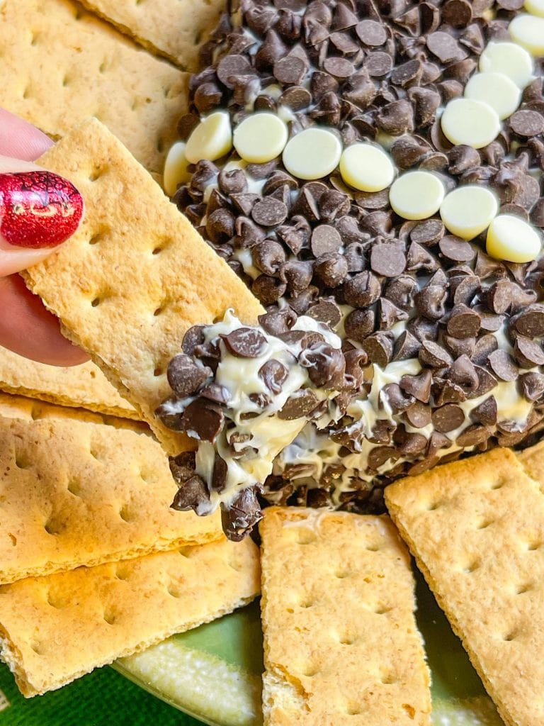 Football Cheesecake Dip is a chocolate chip cheesecake type dip served with graham crackers for dipping. It's a fun and sweet addition to any tailgate table.