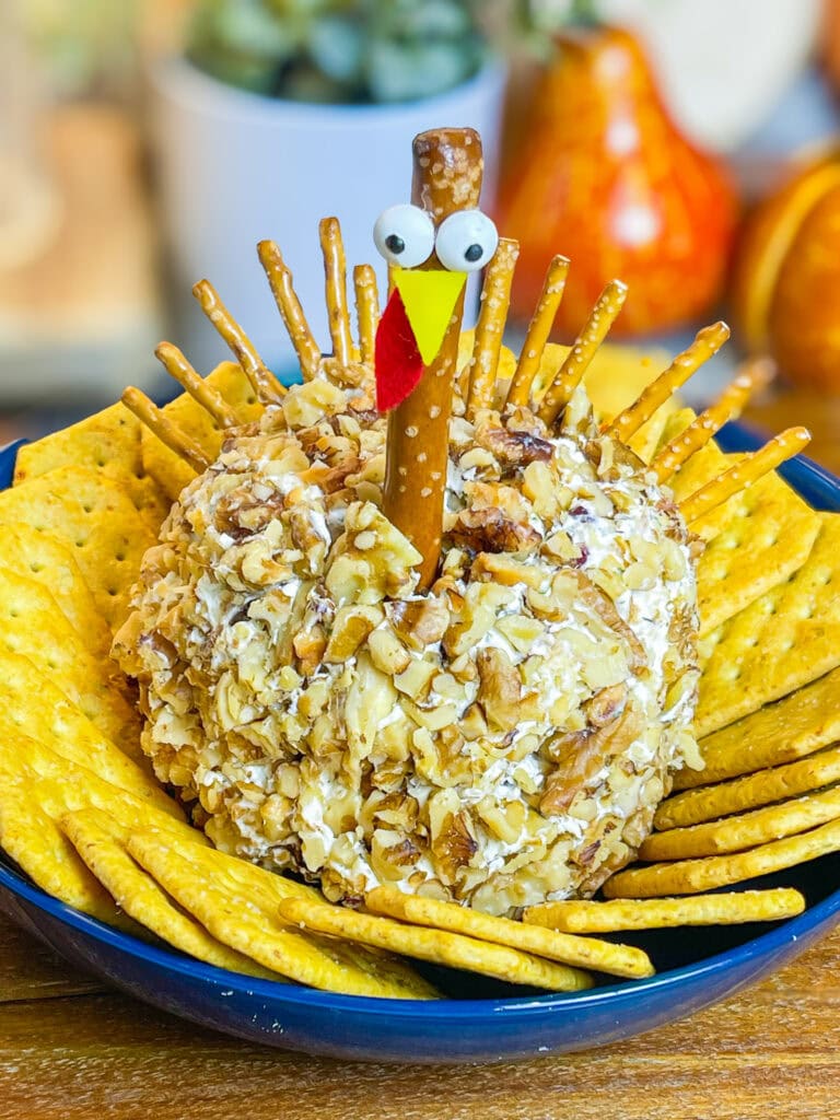 Looking for a crowd-pleasing, festive appetizer for your Thanksgiving table? This adorable Turkey Cheese Ball is not only fun to make but also incredibly delicious. With creamy, tangy layers of cream cheese and white cheddar mixed with savory herbs, walnuts, and a hint of sweet craisins, it’s packed with flavor in every bite. Shaped like a turkey and decorated with a pretzel rod "neck" and candy eyes, this appetizer is sure to be the star of your spread. Paired with pretzel sticks and crackers, it’s the perfect appetizer to kick off your Thanksgiving feast, delighting guests of all ages.