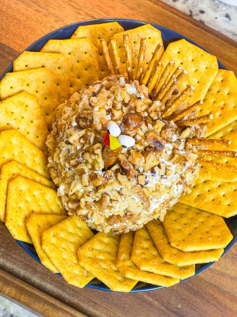 Looking for a crowd-pleasing, festive appetizer for your Thanksgiving table? This adorable Turkey Cheese Ball is not only fun to make but also incredibly delicious. With creamy, tangy layers of cream cheese and white cheddar mixed with savory herbs, walnuts, and a hint of sweet craisins, it’s packed with flavor in every bite. Shaped like a turkey and decorated with a pretzel rod "neck" and candy eyes, this appetizer is sure to be the star of your spread. Paired with pretzel sticks and crackers, it’s the perfect appetizer to kick off your Thanksgiving feast, delighting guests of all ages.